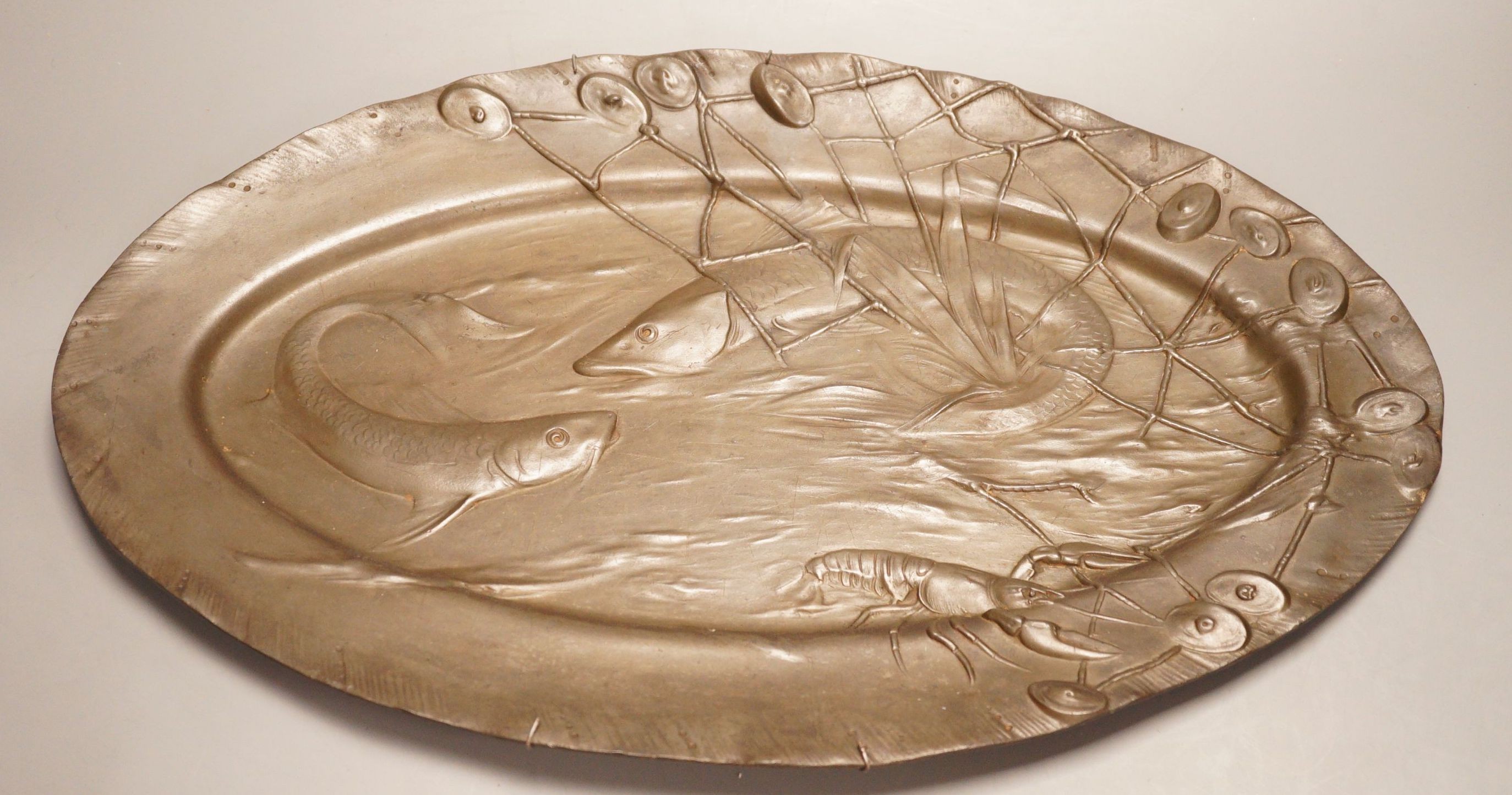 An early 20th century Continental pewter platter, decorated with fish, 52cm